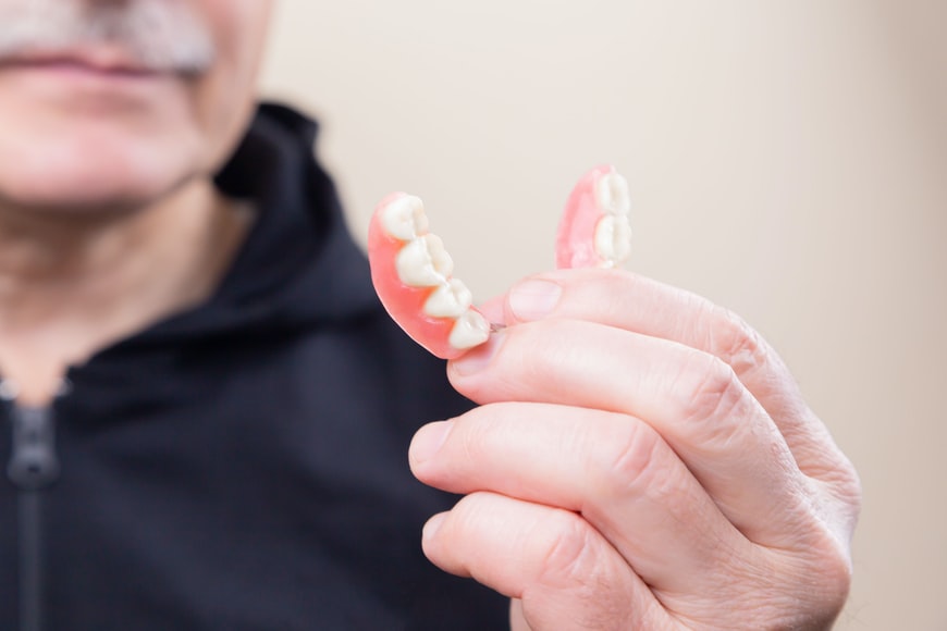 man holding dentures