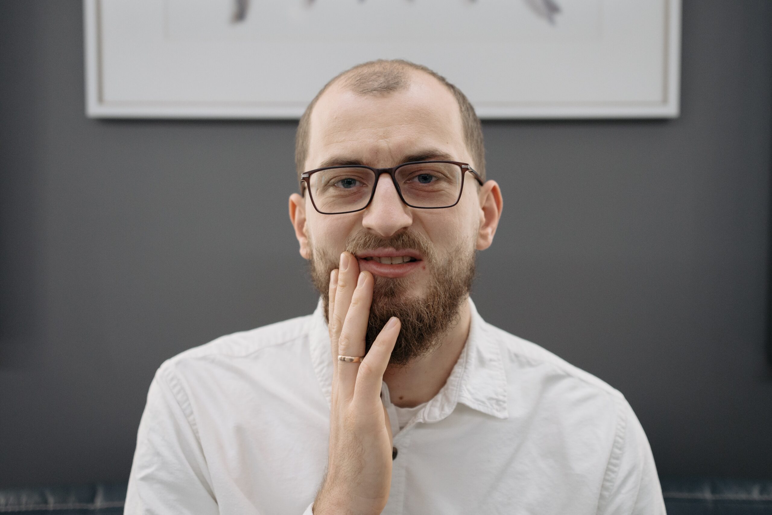 man in white shirt with tooth ache